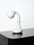 White  Short Ceramic Table Lamp by Entler Studio on a glossy black surface.