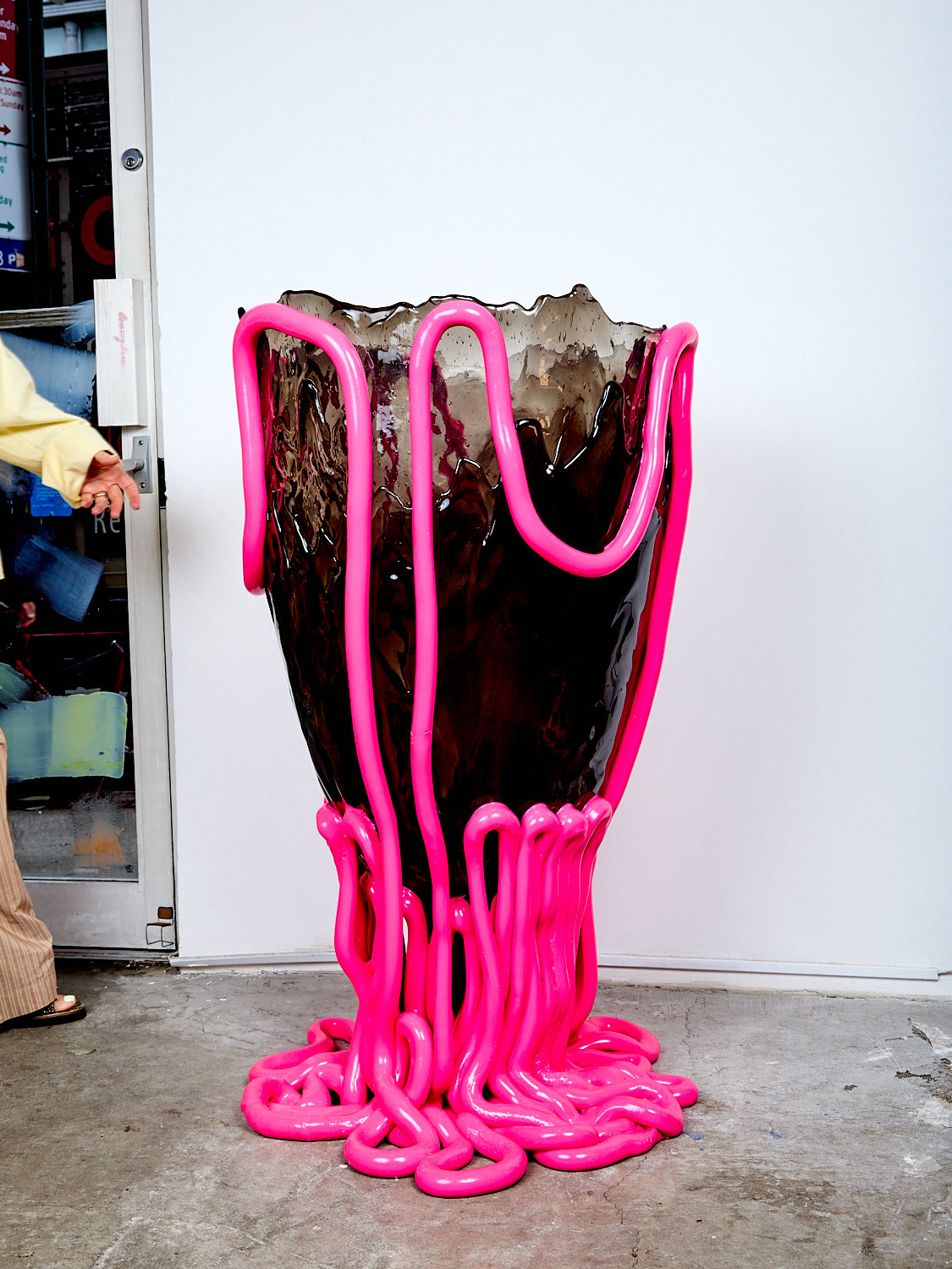 Hot pink and smokey gray Indian Summer Vessel on a concrete floor against a white wall.