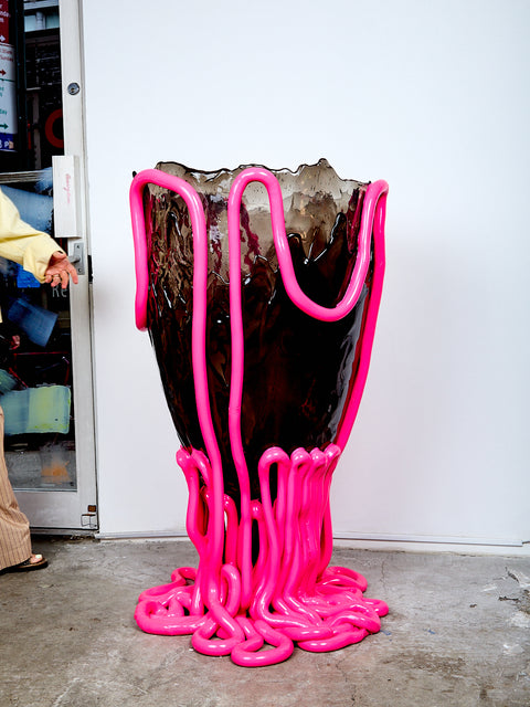 Hot pink and smokey gray Indian Summer Vessel on a concrete floor against a white wall.
