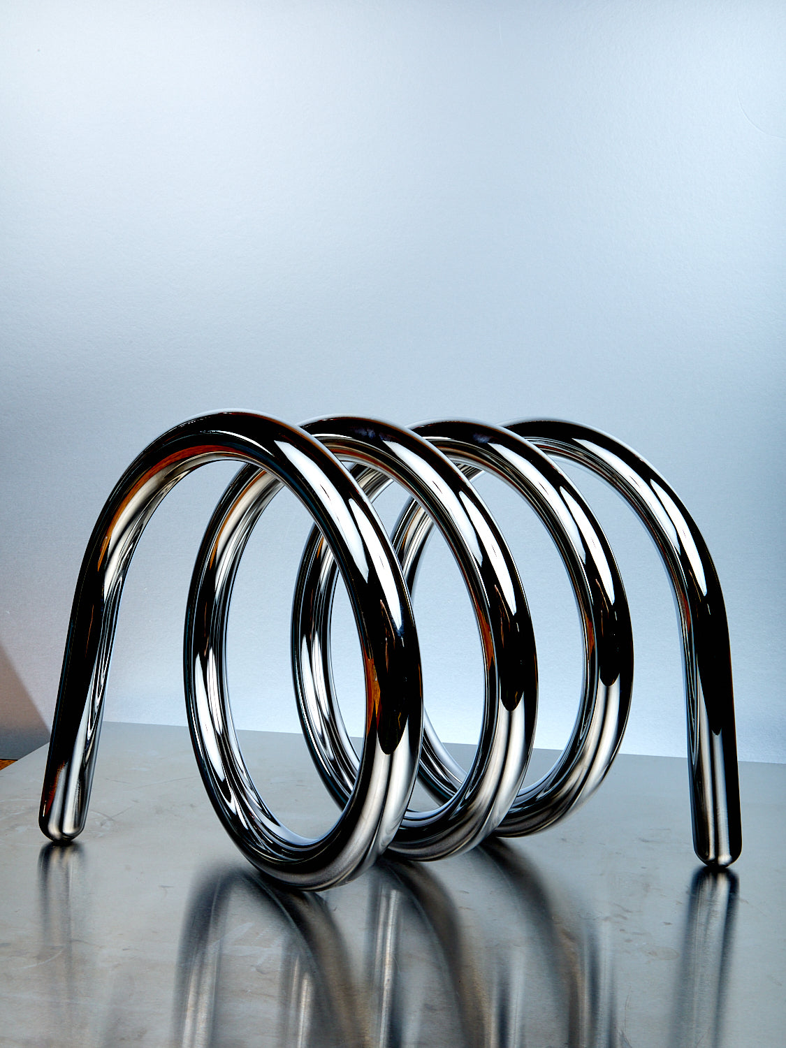 Metallic spiral design on a reflective surface with a gradient background