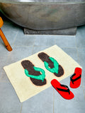 Bath mat with flip-flop designs on a tiled floor next to a bathtub.