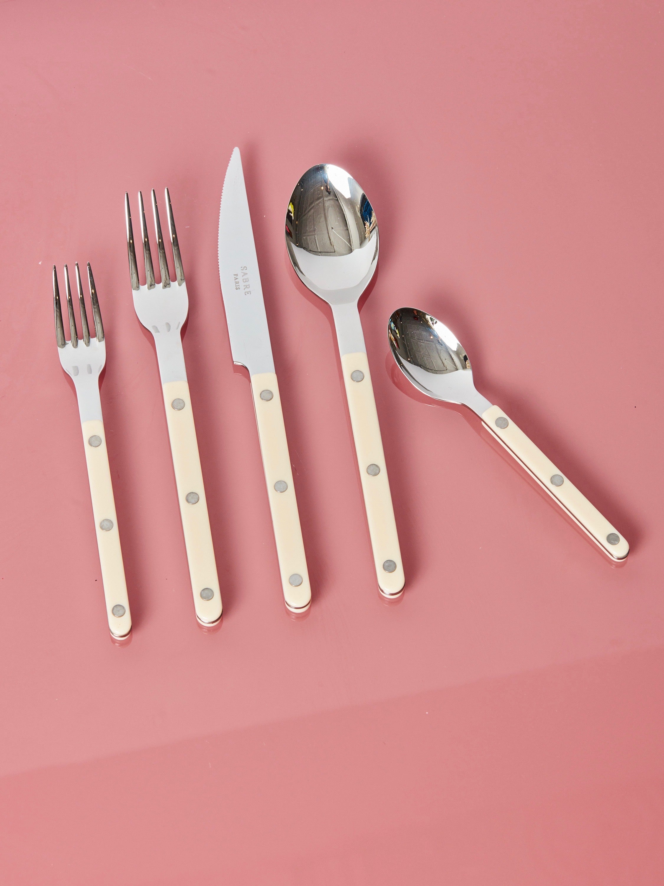 Ivory salad fork, dinner fork, dinner knife, dinner spoon, and teaspoon by Sabre.